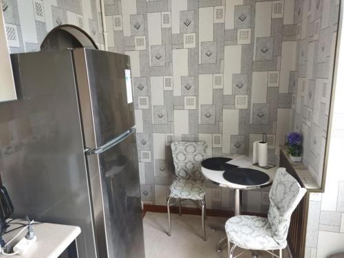 uma cozinha com uma mesa e um frigorífico em Apartment near Tashkent metro station and convenient location em Tashkent