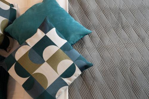 a couple of pillows on a bed next to a wall at PHOENIX maison d'hôtes & SPA in Ginasservis