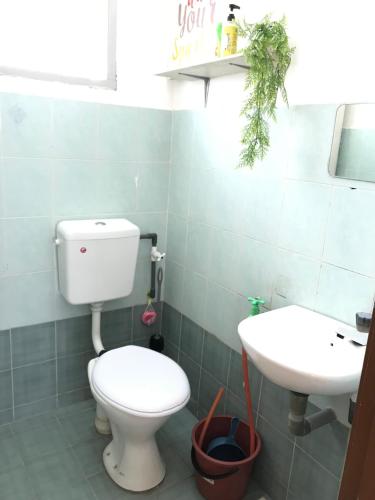 y baño con aseo y lavamanos. en Solehah Homestay, en Seri Iskandar