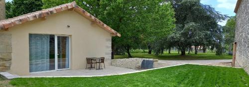 a small house with a table in a yard at L'atelier d'André in Monbahus