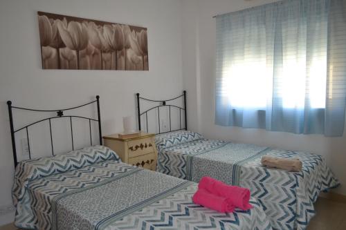 dos camas sentadas una al lado de la otra en un dormitorio en Triplex a 200 metros de la playa, en Gandía