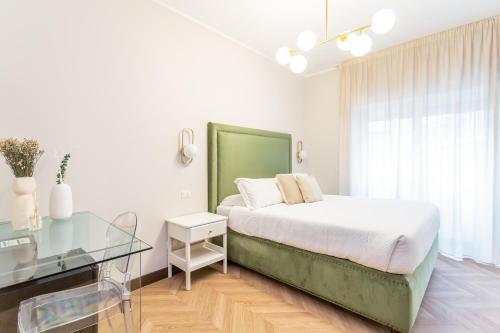 a white bedroom with a bed and a glass table at Daplace - Gran Torino Suites in Rome