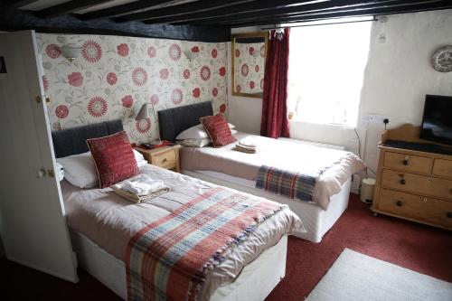 a bedroom with two beds and a window at Ty Seren in Dolgellau