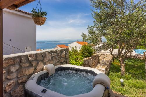 a hot tub in a stone wall in a yard at Marie in Crikvenica