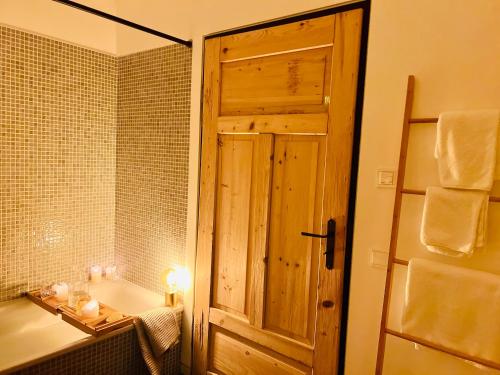 a bathroom with a wooden door and a bath tub at simsseeLOFT -Architektur trifft Seenähe in Stephanskirchen