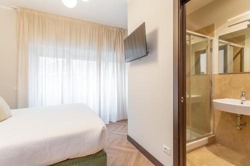 a bedroom with a bed and a bathroom with a sink at Daplace - Gran Torino Suites in Rome