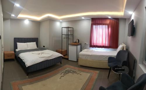 a bedroom with two beds and a window and a chair at Torch Suit in Istanbul