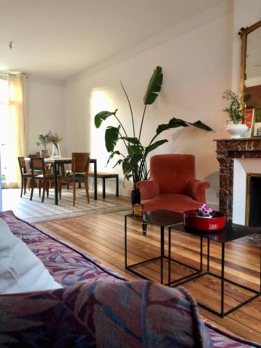 - un salon avec une chaise et une cheminée dans l'établissement Maison et jardin à Epernay centre ville, à Épernay
