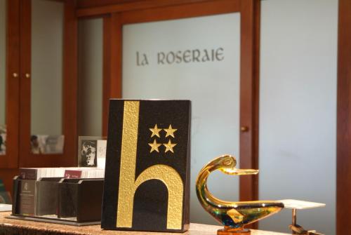 a sign that says la roostride with a gold dinosaur on a table at La Roseraie. Gaume-Ardenne-lacuisine sur Semois. in Florenville