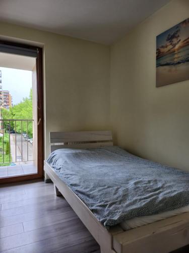 a bedroom with a bed and a large window at Miły czas in Kraków