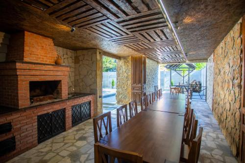 een eetkamer met een tafel en een open haard bij Hotel West Way in Koetaisi