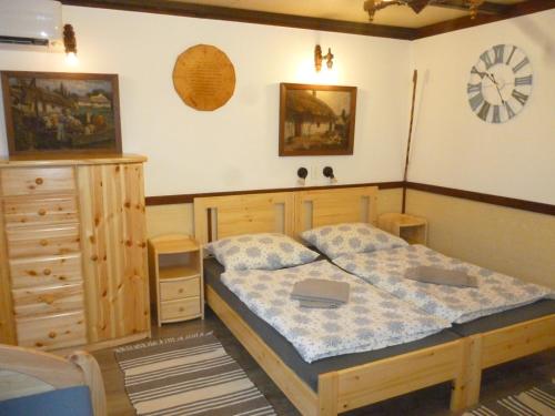 a bedroom with a bed and a dresser at Vincellér Vendégház 