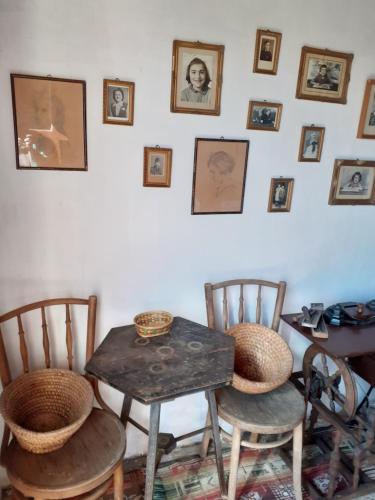 a room with a table and chairs and pictures on the wall at Vincellér Vendégház in Királyszentistván