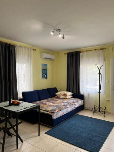 a living room with a blue couch and a table at Galini Apartments in Litochoro