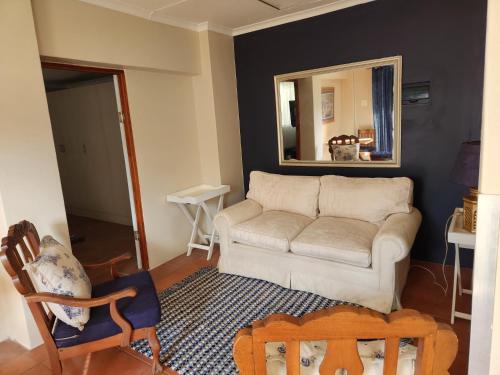 a living room with a couch and a mirror at One bedroom house in Boksburg