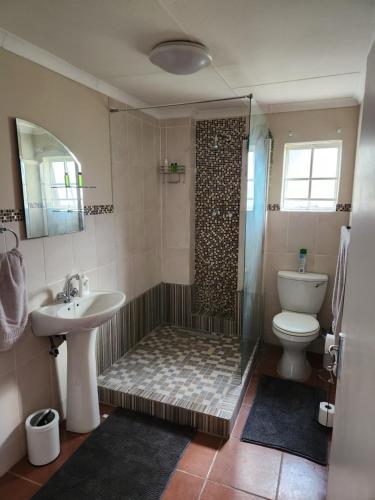 a bathroom with a shower and a toilet and a sink at One bedroom house in Boksburg