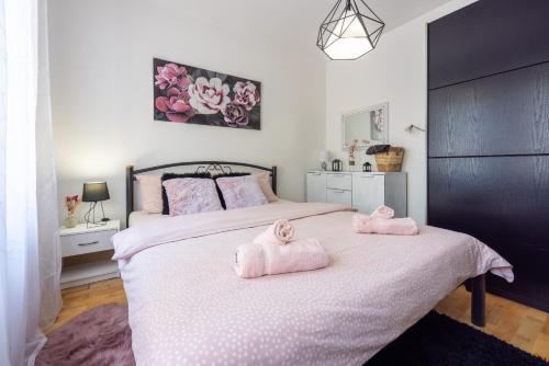 - une chambre avec 2 serviettes roses sur un lit dans l'établissement Marie, à Crikvenica