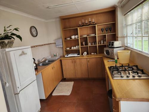 a kitchen with a white refrigerator and a stove at One bedroom house in Boksburg