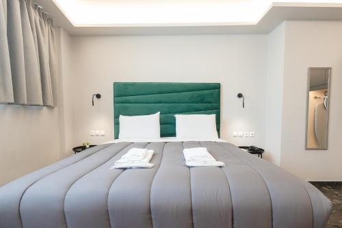 a large bed with two towels on top of it at City Life Athens Apartments in Athens