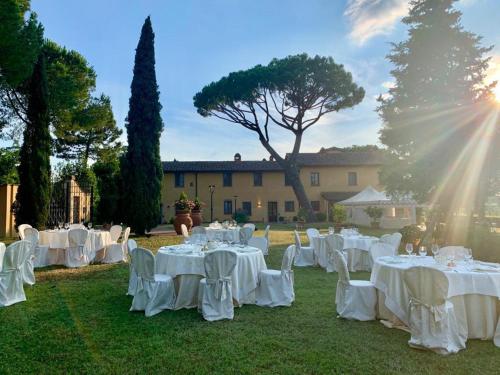 a group of tables with white linens on the grass at Agriturismo Bellavista in San Miniato