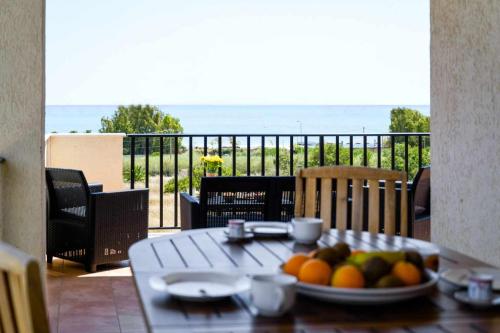 a table with a plate of fruit on a balcony at Casamici Sampieri Centosicilie in Sampieri