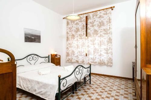 a bedroom with a black bed and a window at Casamici Sampieri Centosicilie in Sampieri