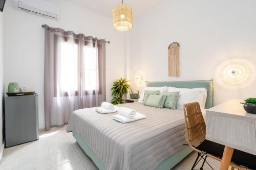 een witte slaapkamer met een bed met handdoeken erop bij NaxosAir1 in Naxos Chora