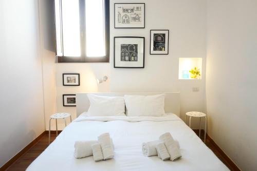 una camera da letto con un grande letto bianco con due cuscini di I'MC IoAMoCagliari a Cagliari