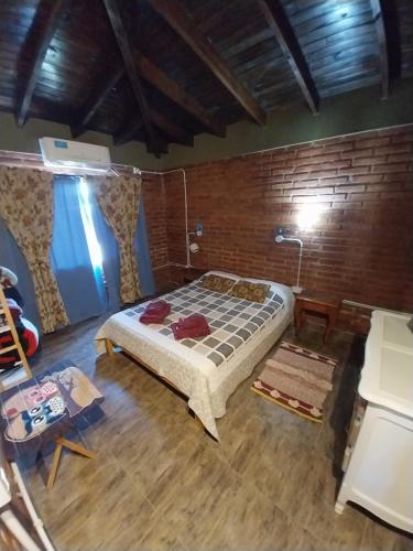 1 dormitorio con 1 cama y pared de madera en Gilgal en Sierra de la Ventana