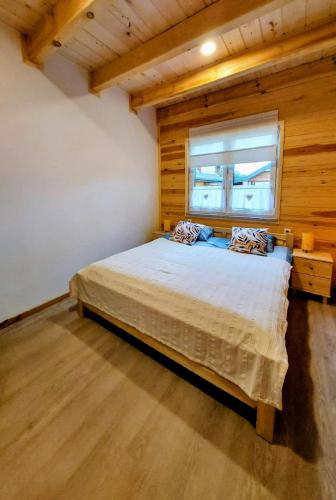 a bedroom with a bed in a room with a window at Niemirowska Osada in Niemirów