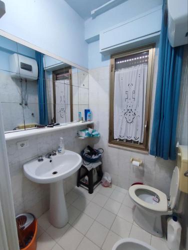 a bathroom with a sink and a toilet and a window at Licia Comfort Zone in Sciacca