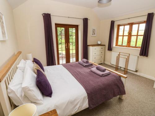 a bedroom with a large bed with purple pillows at Ty Rhosyn in Haverfordwest
