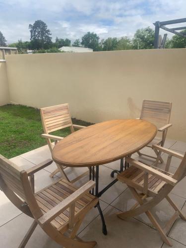 une table en bois, 2 chaises, une table et des chaises dans l'établissement villa bleu marine chic calme et jardin, à Andrézieux-Bouthéon