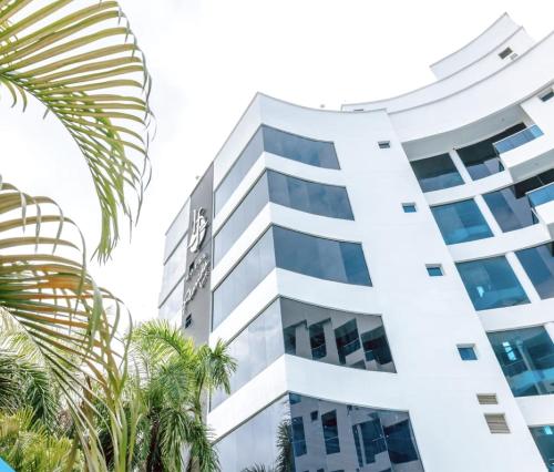 a tall white building with palm trees in front of it at Hotel Florida Sinú in Montería