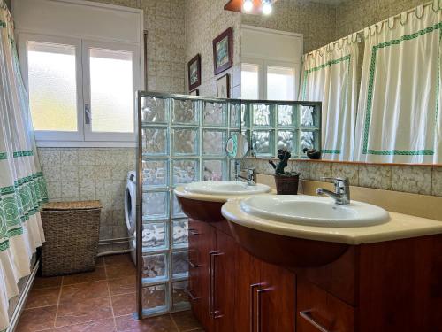 a bathroom with two sinks and a large mirror at Vivalidays Casa Ricardo in Sant Cebrià de Vallalta