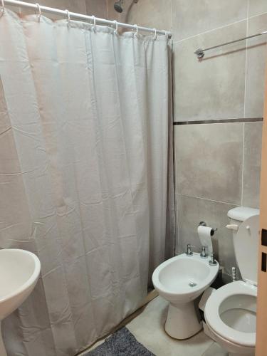 y baño con aseo y cortina de ducha. en Departamento Corrientes capital en Corrientes