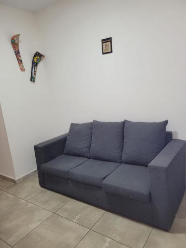 un sofá azul sentado contra una pared blanca en Departamento Corrientes capital en Corrientes
