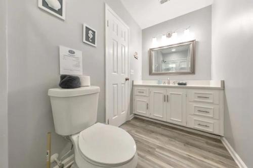 a white bathroom with a toilet and a sink at Sandy Feet Retreat in Panama City Beach