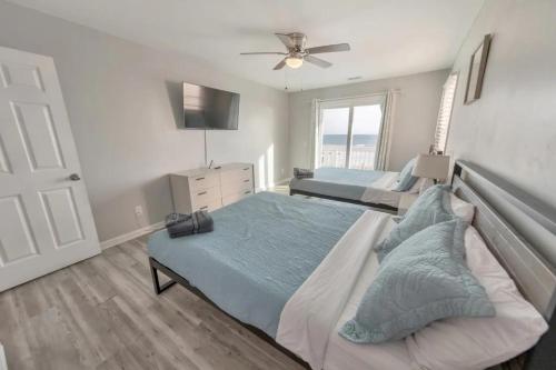 a bedroom with two beds and a ceiling fan at Sandy Feet Retreat in Panama City Beach