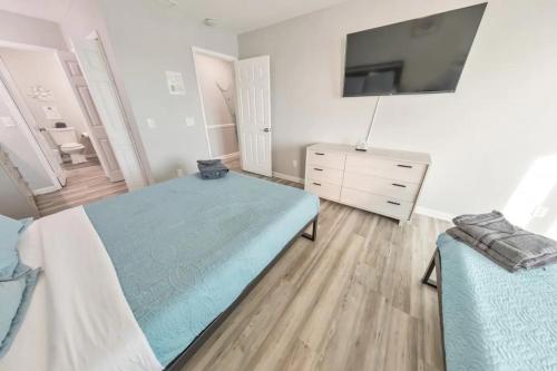 a bedroom with a bed and a tv on a wall at Sandy Feet Retreat in Panama City Beach