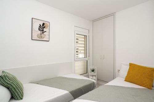 リョレート・デ・マルにあるApartment Bitacora FULLY RENOVATED 2023の白い部屋で、ベッド2台、窓が備わります。