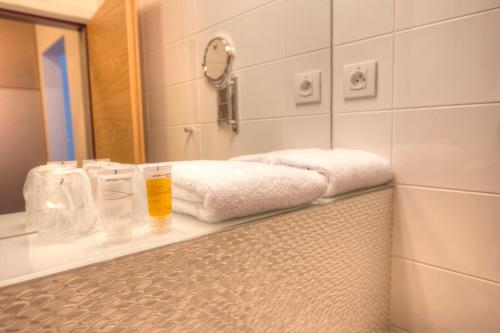 a bathroom with a counter with towels and a mirror at Hotel Vinice Hnanice in Hnanice