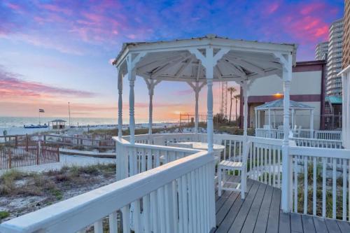 a deck with a gazebo on the beach at Sandy Feet Retreat in Panama City Beach