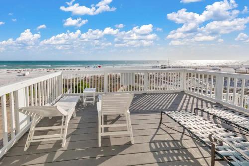 a balcony with tables and chairs and the beach at Sandy Feet Retreat in Panama City Beach