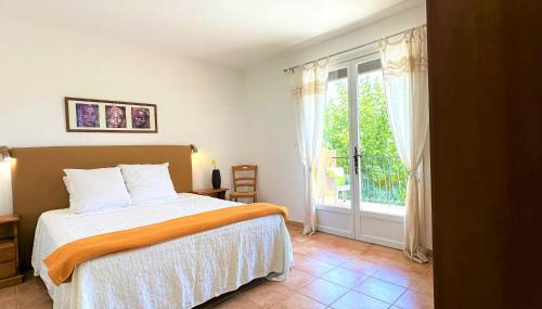 a bedroom with a bed and a sliding glass door at Les Terrasses de Figanières in Figanières