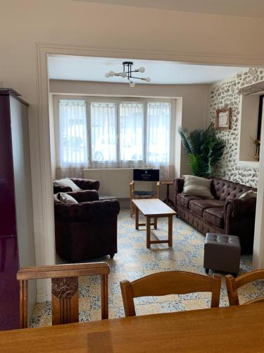 a living room with couches and a table at Villa Mirroir en Champagne, jusque 10 voyageurs in Boursault
