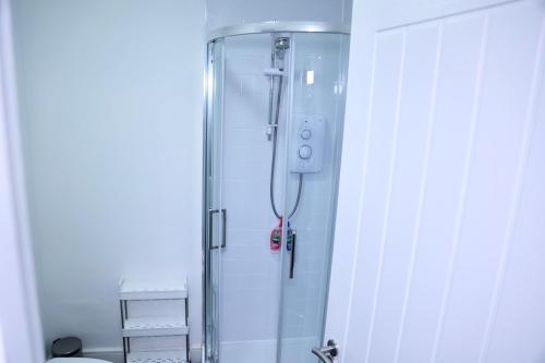 eine Dusche im Bad mit Glastür in der Unterkunft Nottingham Brand New 1BR Apt w/ Full Kitchen City in Nottingham