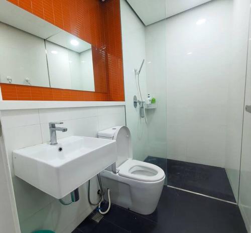 a bathroom with a white sink and a toilet at Arcoris SOHO Mont Kiara in Kuala Lumpur