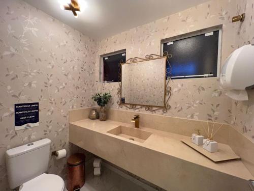La salle de bains est pourvue d'un lavabo et d'un miroir. dans l'établissement Pousada Recanto Forte, à Florianópolis