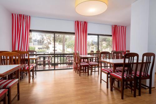 - une salle à manger avec des tables, des chaises et des fenêtres dans l'établissement Hotel Verde Pinho Bed&Breakfast, à São Pedro de Muel